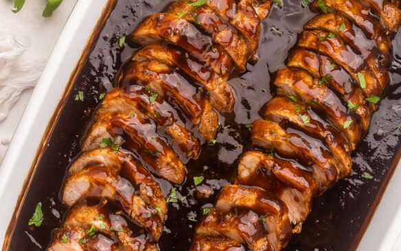 overhead view of dish full of sliced pork tenderloin in honey balsamic sauce.