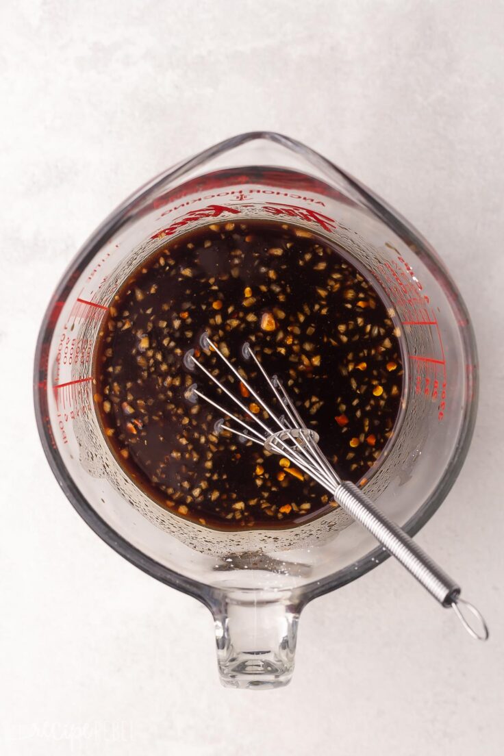 glass measuring cup with whisk and honey balsamic sauce.