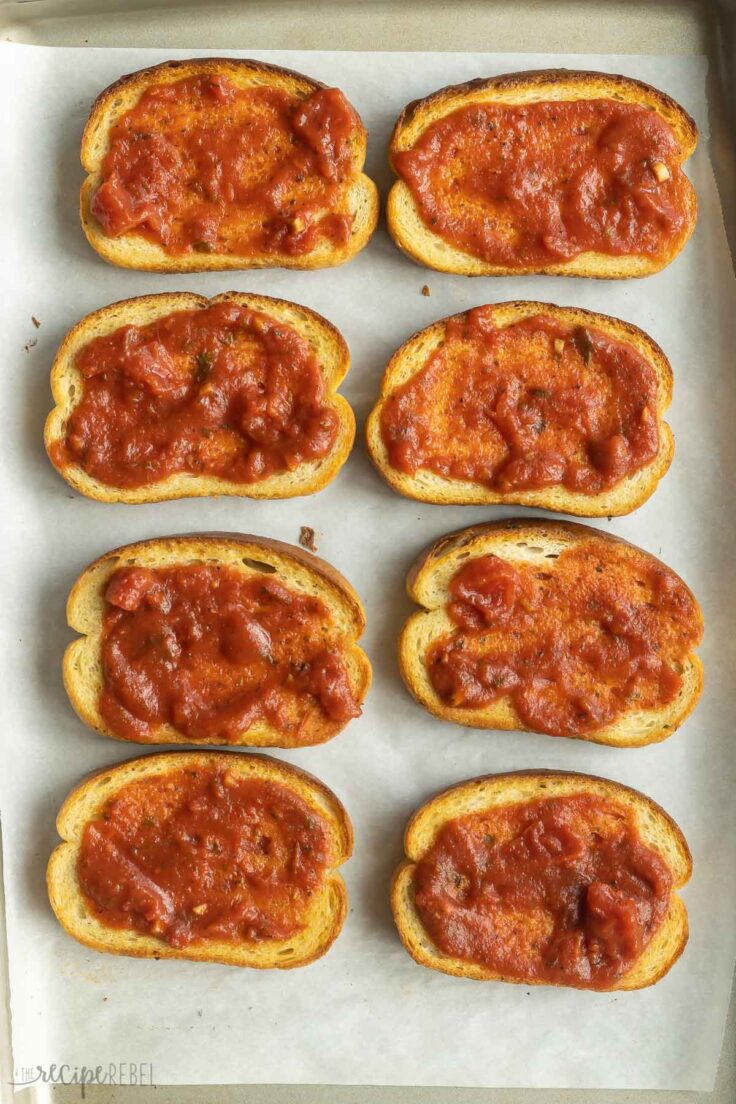 pizza sauce on toasted garlic bread slices.