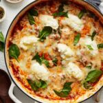 close up of three cheese gnocchi bake in pot garnished.