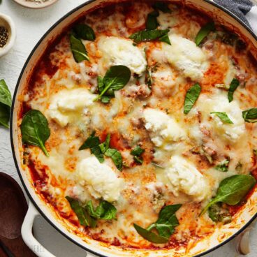 close up of three cheese gnocchi bake in pot garnished.