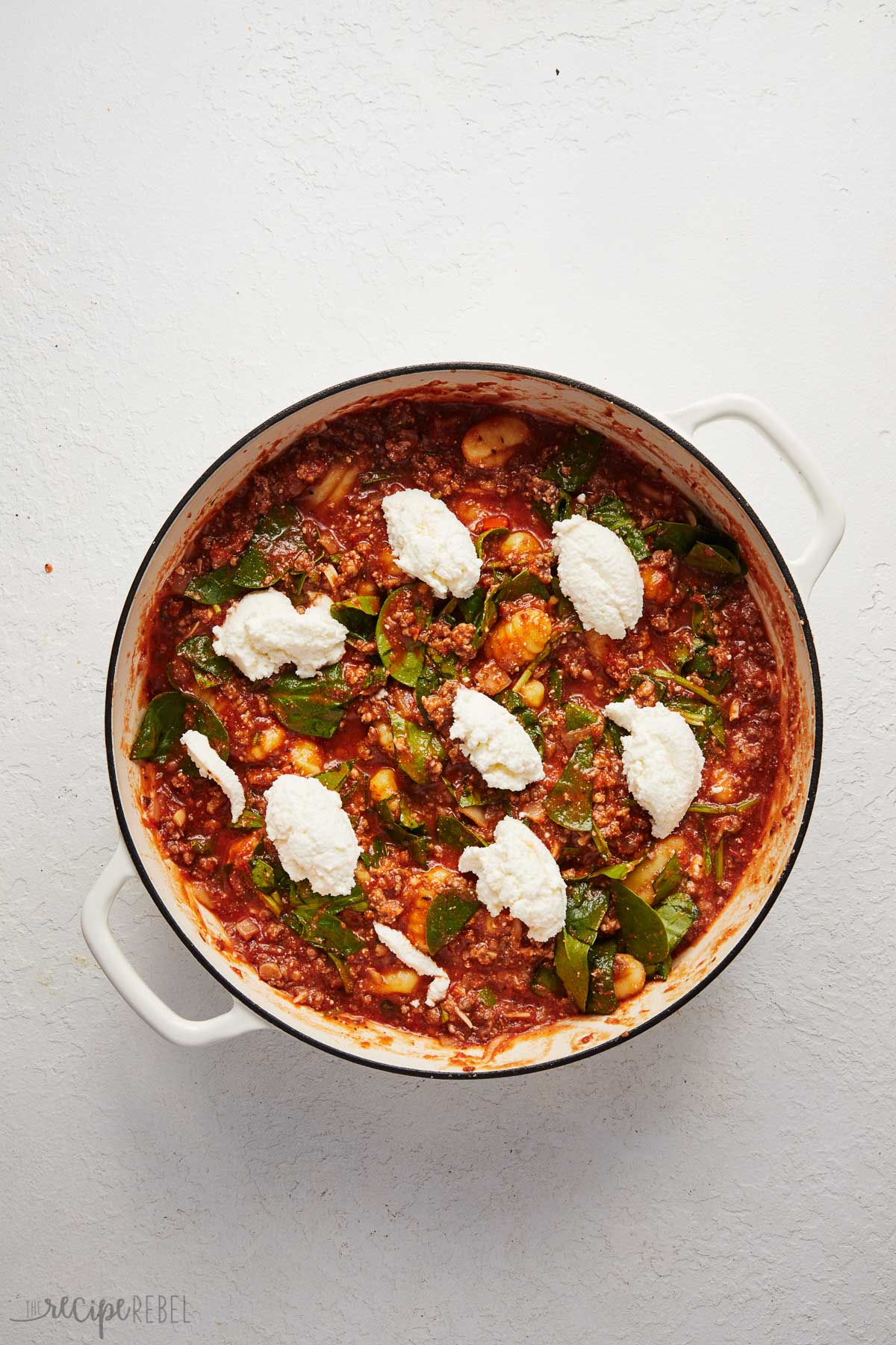 overhead view of three cheese gnocchi bake with ricotta added on top.