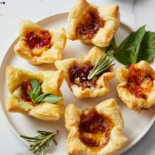 Top view of baked brie bites on a white plate.