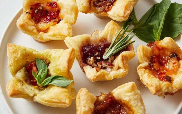 Top view of baked brie bites on a white plate.