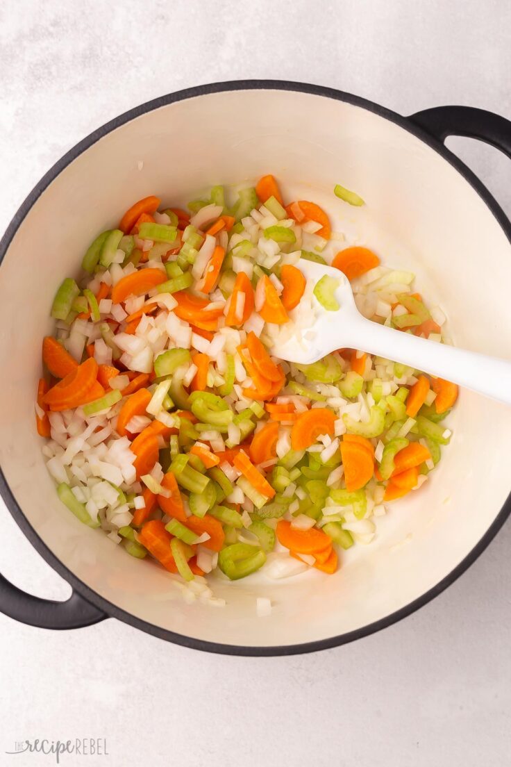 large pot filled with chopped vegetables and a white spatula.