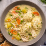 close up of a grey bowl filled with chicken dumpling soup.