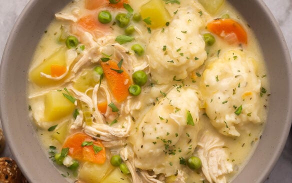 close up of a grey bowl filled with chicken dumpling soup.