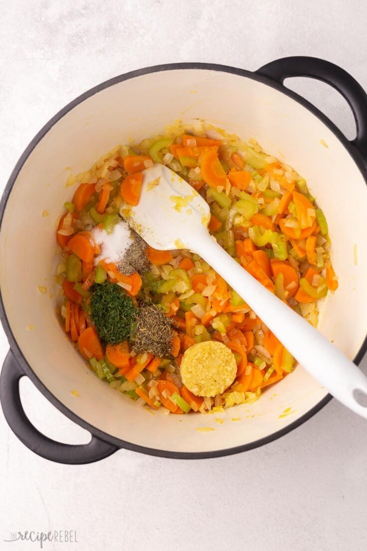 sauteed vegetables in large pot with spices added on top.