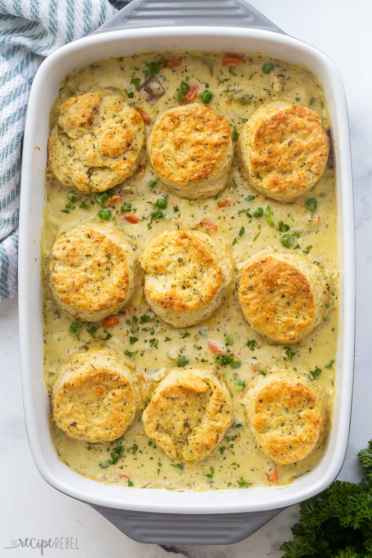 overhead image of chicken pot pie casserole with biscuits in baking dish.