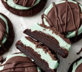 overhead shot of halved chocolate mint cookies on parchment paper.