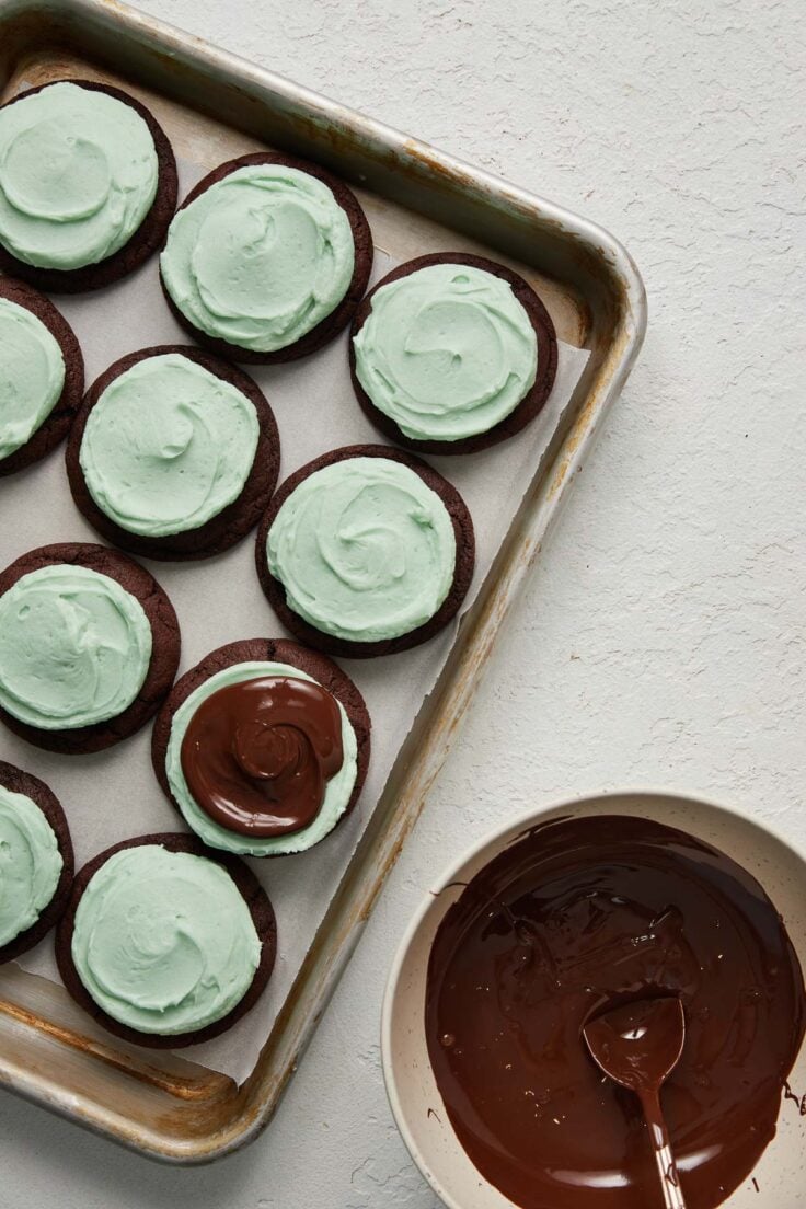 pan of chocolate mint cookies with a bowl of melted chocolate beside.