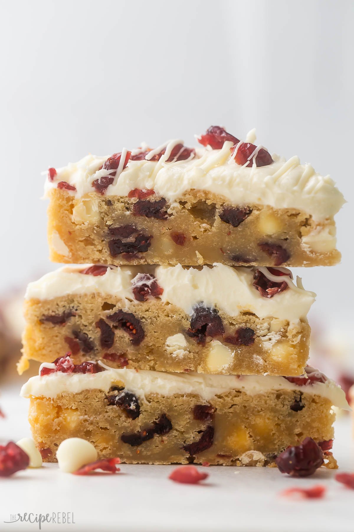 three cranberry bliss bars stacked on top of each other.