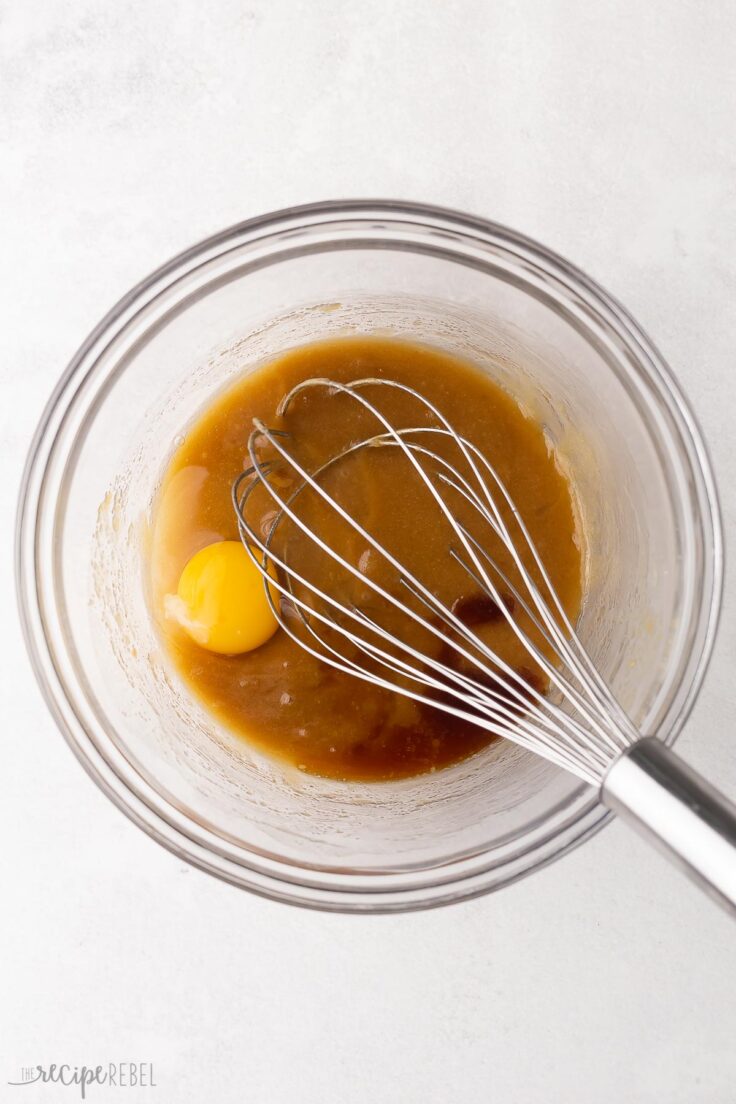 glass bowl with whisked ingredients and an egg added.