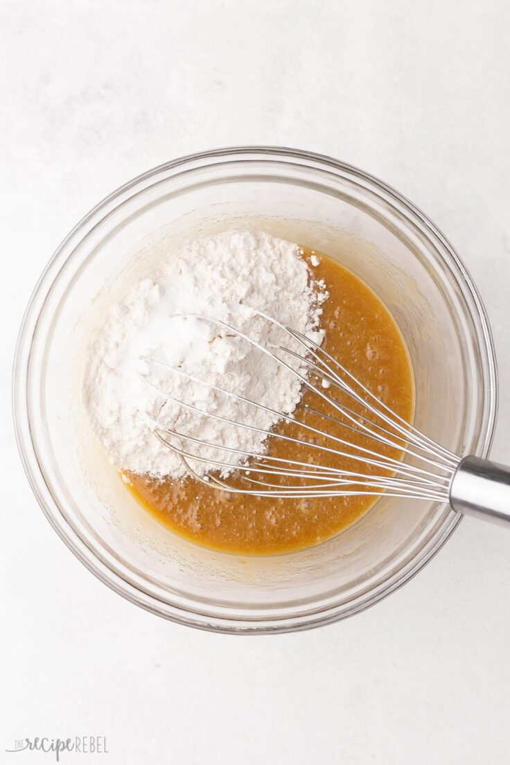 a glass bowl with whisked ingredients and flour added.