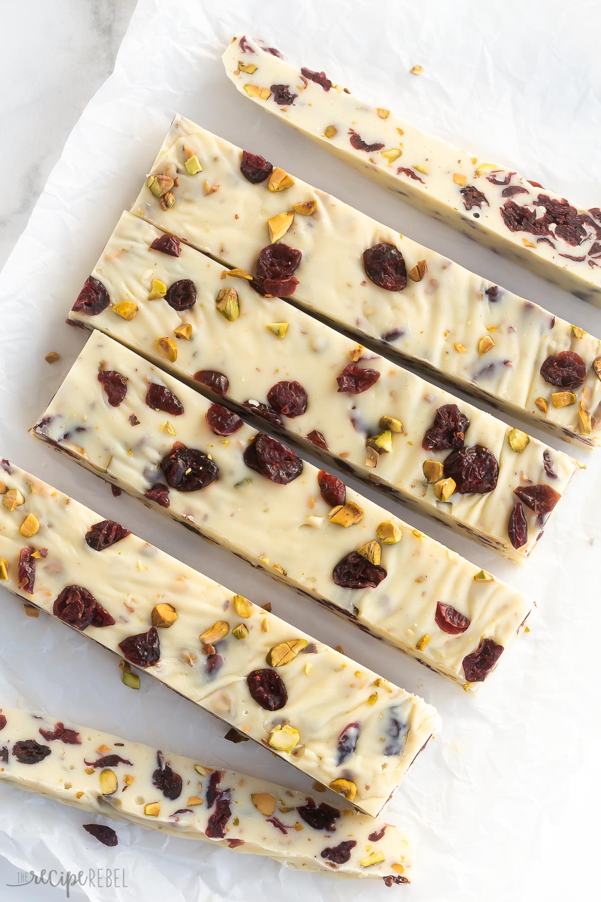 strips of cranberry white chocolate fudge on parchment paper.
