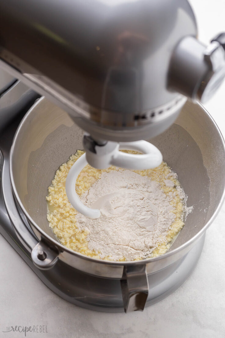 mixer bowl in mixer with flour added to other ingredients.