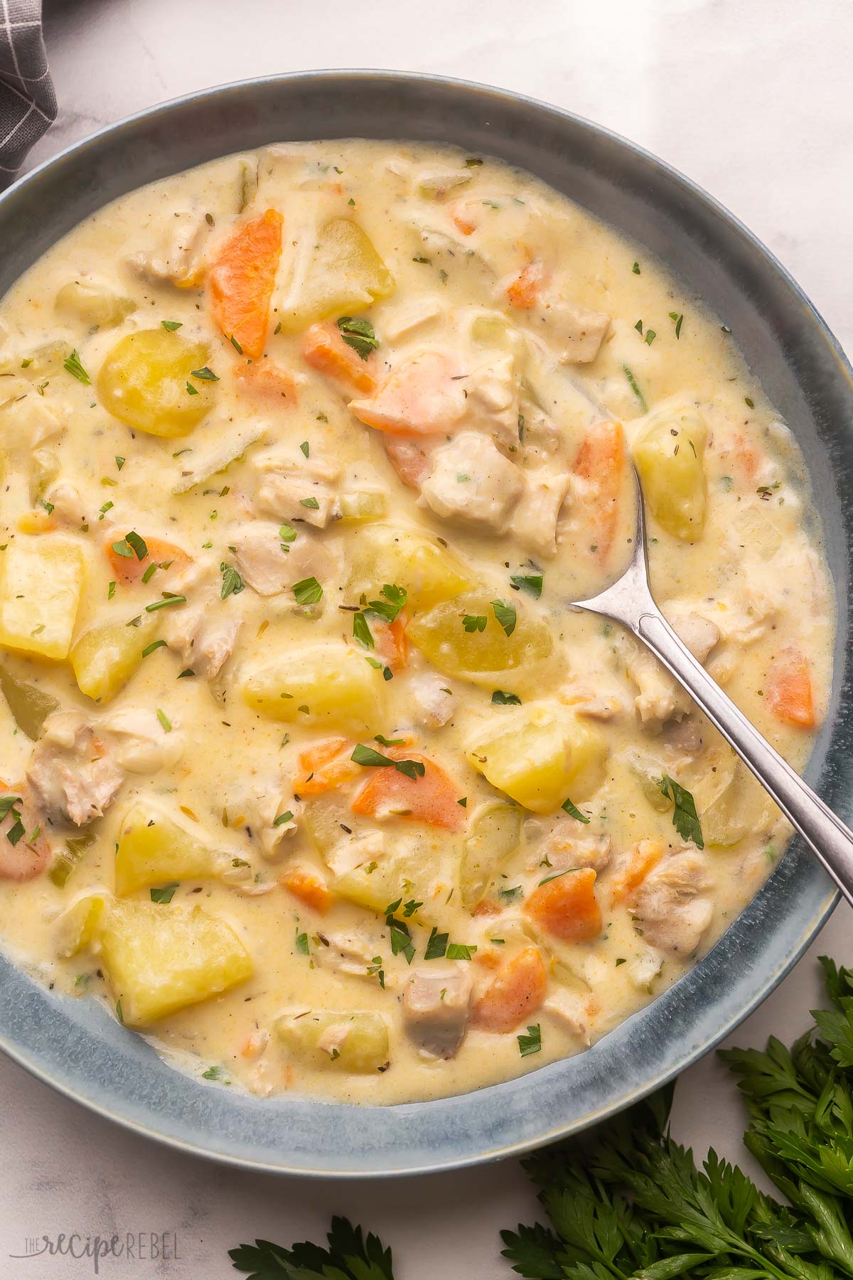 a grey bowl full of leftover turkey soup with spoon.