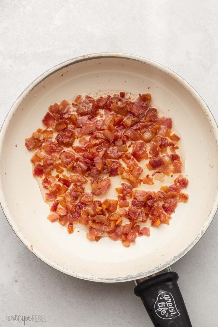 overhead view of a frying pan with cooked bacon bits.