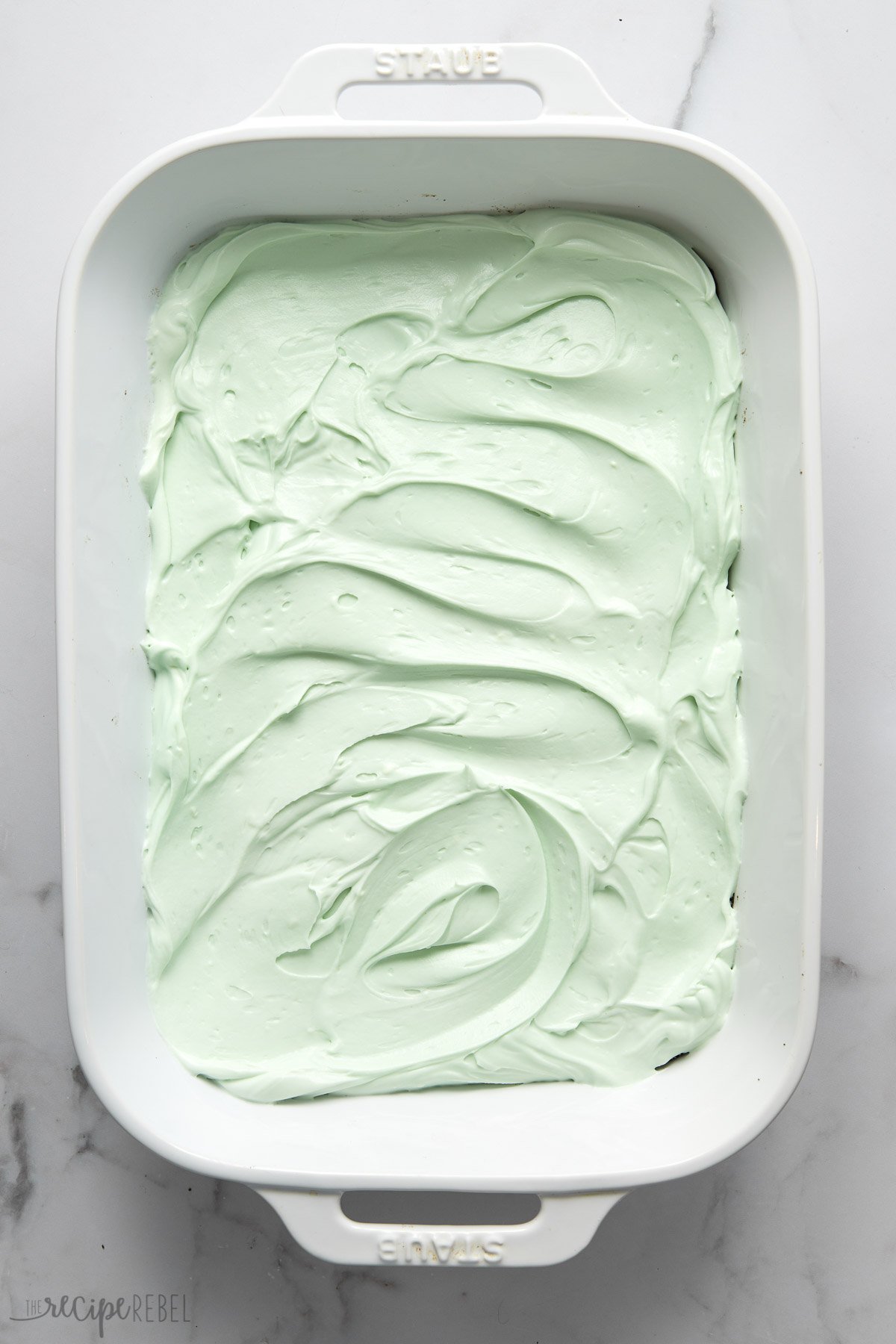 overhead shot of a white pan with mint layer spread.