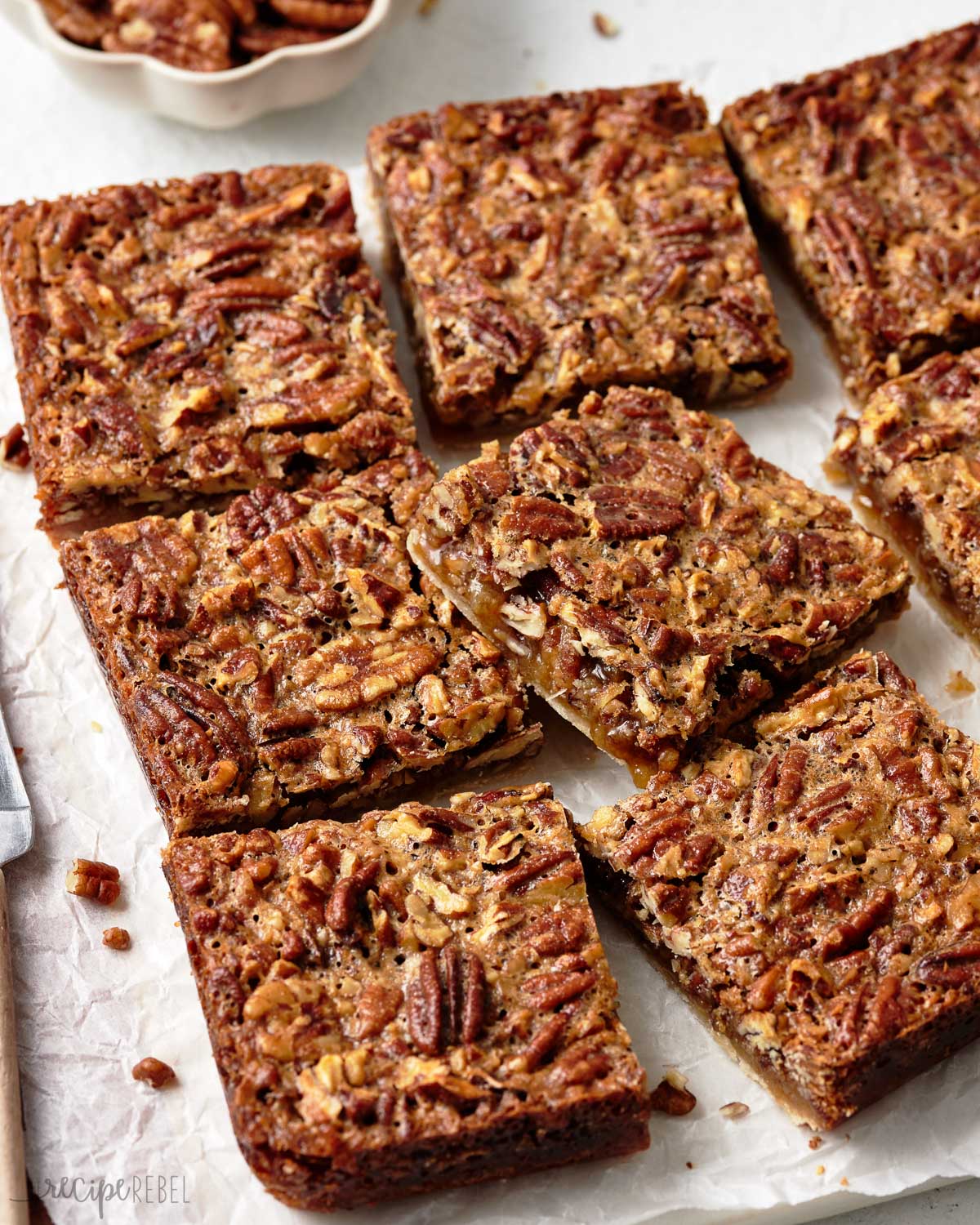 These delicious Pecan Pie Bars are the ultimate fall treat for the holidays! With a thick, buttery shortbread crust and a rich pecan pie filling on top, they are every pecan pie lover's dream! #dessert #baking | pecan recipe | thanksgiving dessert | fall dessert | easy dessert recipe Freshly sliced pecan pie bars.