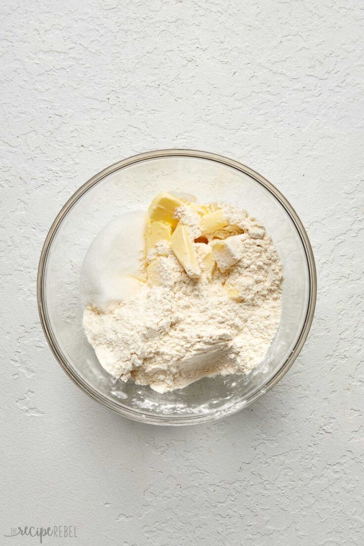 Top view of a glass mixing bowl with shortbread ingredients in it.