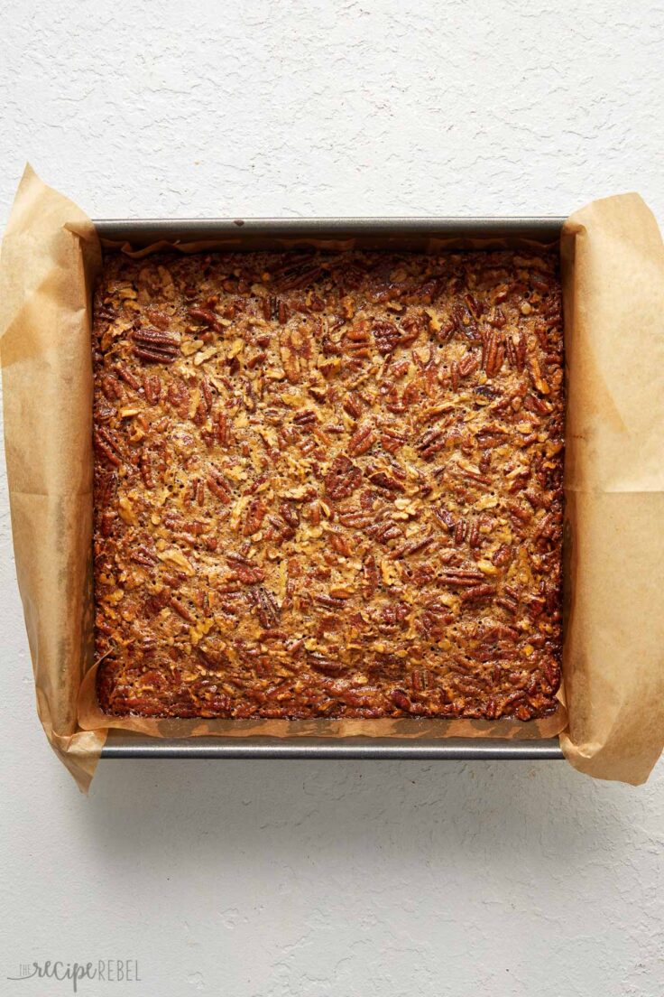 Top view of freshly baked pecan pie bar slab in a baking tray.