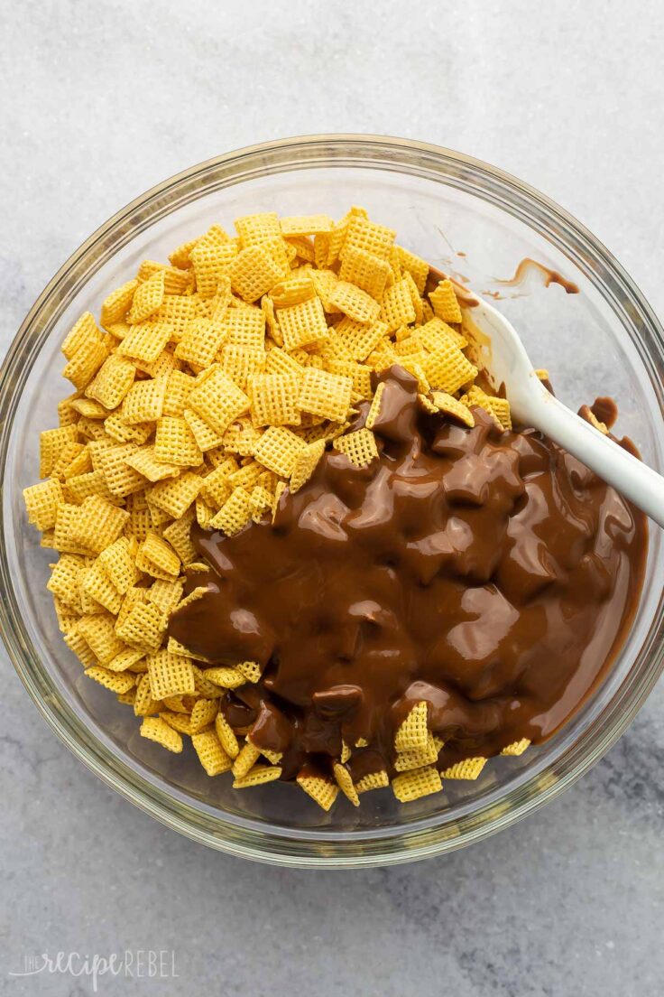 melted chocolate poured onto cereal in a glass bowl.