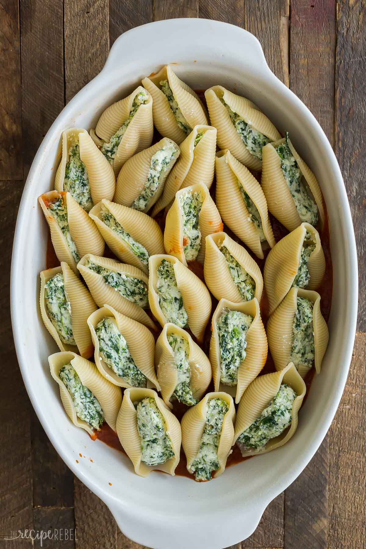 ricotta stuffed shells in white baking dish before sauce is added.