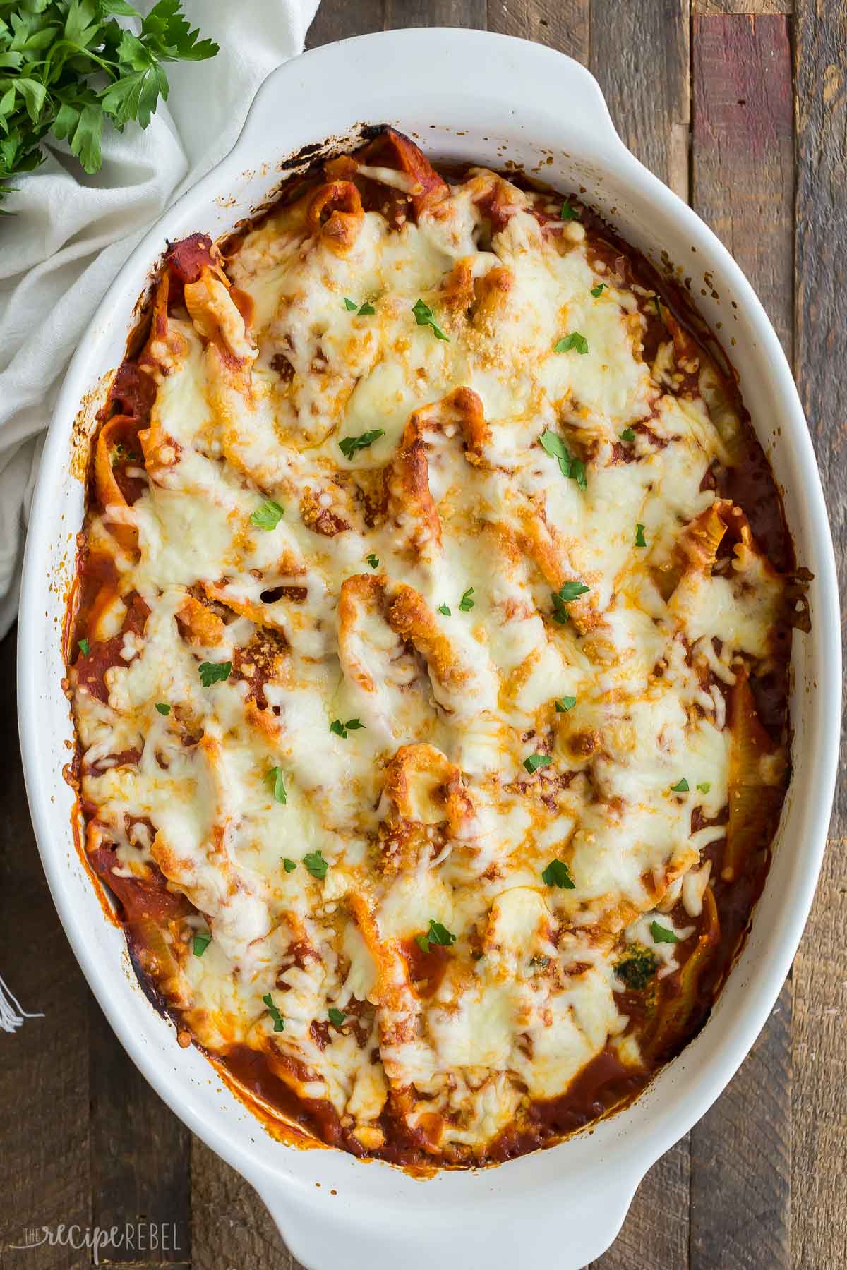 This Ricotta Stuffed Shells recipe is creamy, comforting, easy to make ahead and freezer friendly! Perfect for freezer meal prep and busy weeknights. #recipe #dinner #pasta #cheese #cooking finished ricotta stuffed shells in white baking dish.