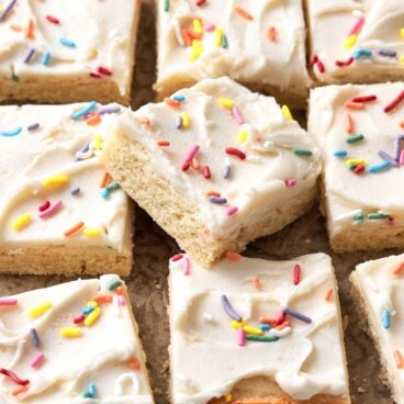 Close up of sugar cookie bar squares on a surface.