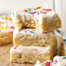 Sugar Cookie Bars wth sprinkles on them in a stack on a worktop.