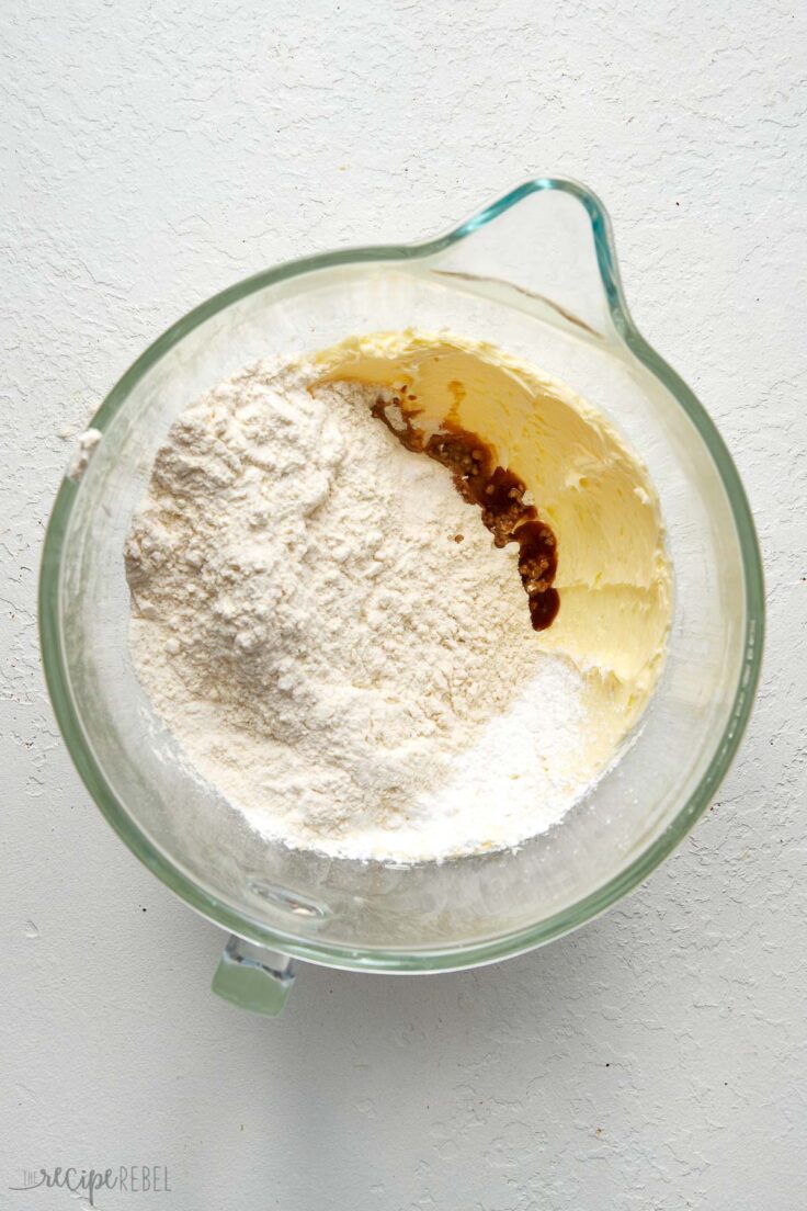 dry ingredients in glass mixing bowl on white surface.