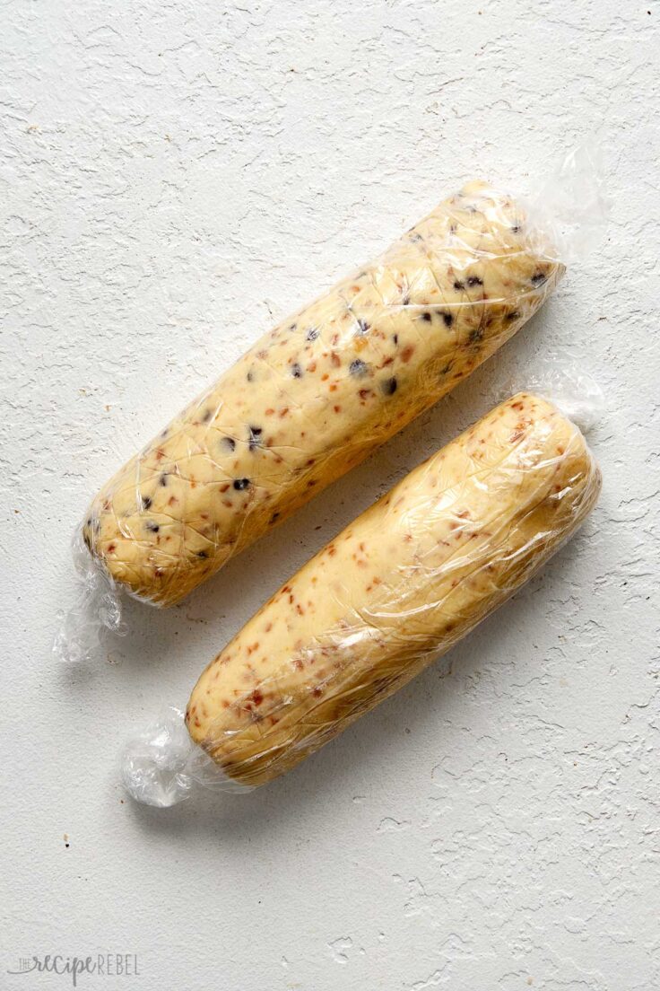 two logs of toffee shortbread rolled in plastic wrap.