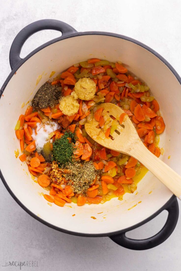 large pot filled with sauteed vegetables, spices and wooden ladle.