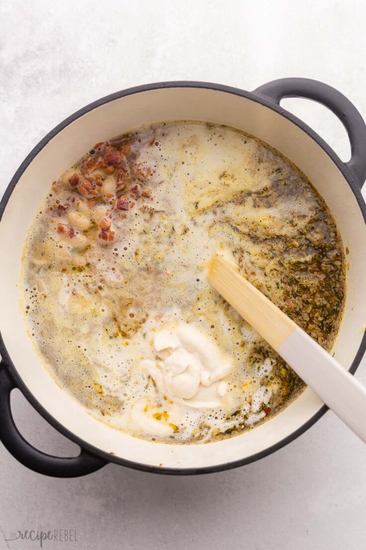 bacon white bean soup in pot with wooden laldle.