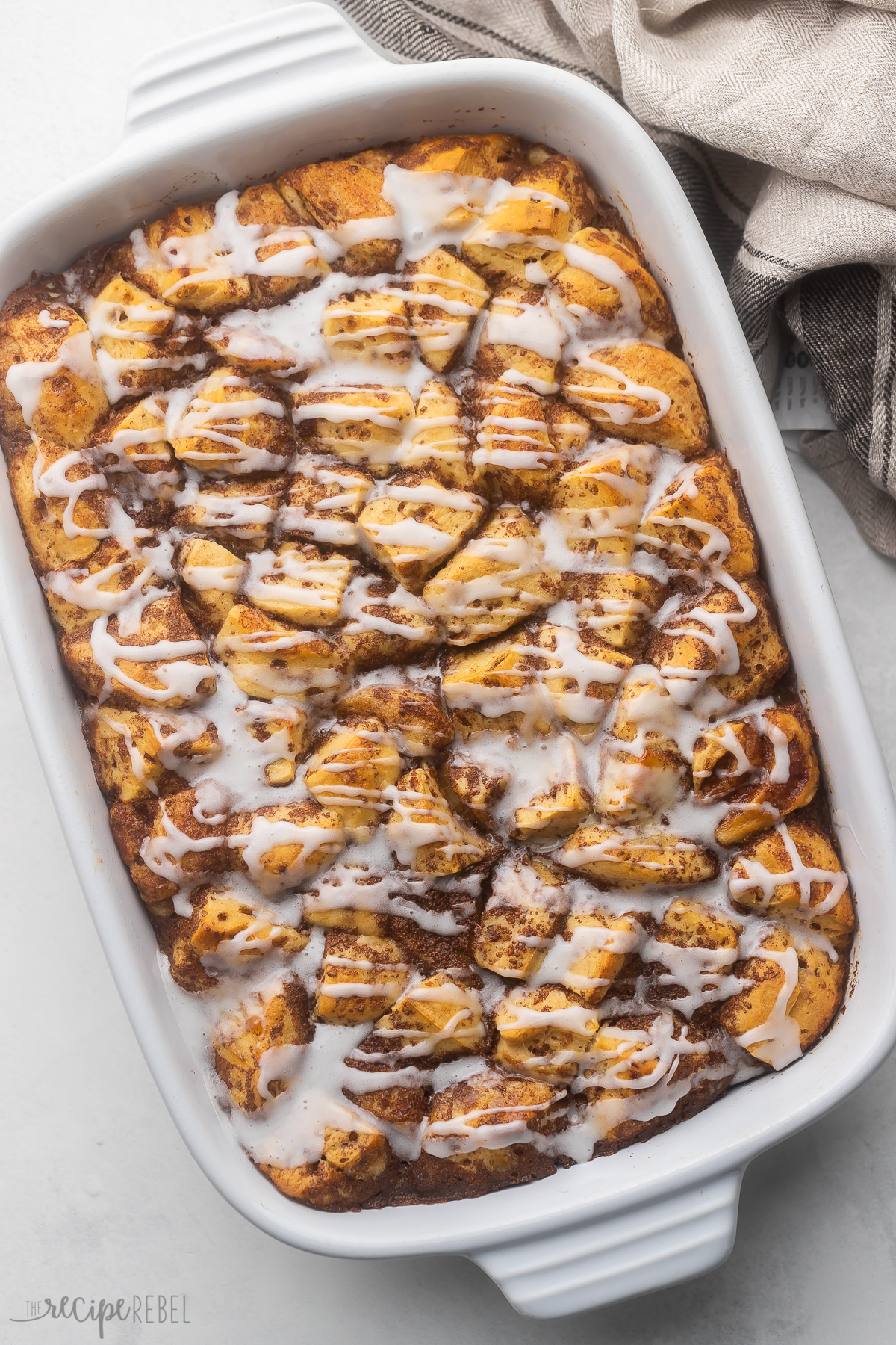 Easy Cinnamon Roll Casserole is the perfect breakfast to wake up to on Christmas morning! Made with delicious cinnamon roll pieces soaked in a warming syrup with vanilla and cinnamon, they're topped with frosting for a deliciously decadent breakfast perfect for the whole family! #breakfast #recipe | breakfast recipes | brunch recipes | casserole recipe | christmas recipe | christmas breakfast | brunch recipe | cinnamon rolls Top view of Cinnamon Roll Casserole.