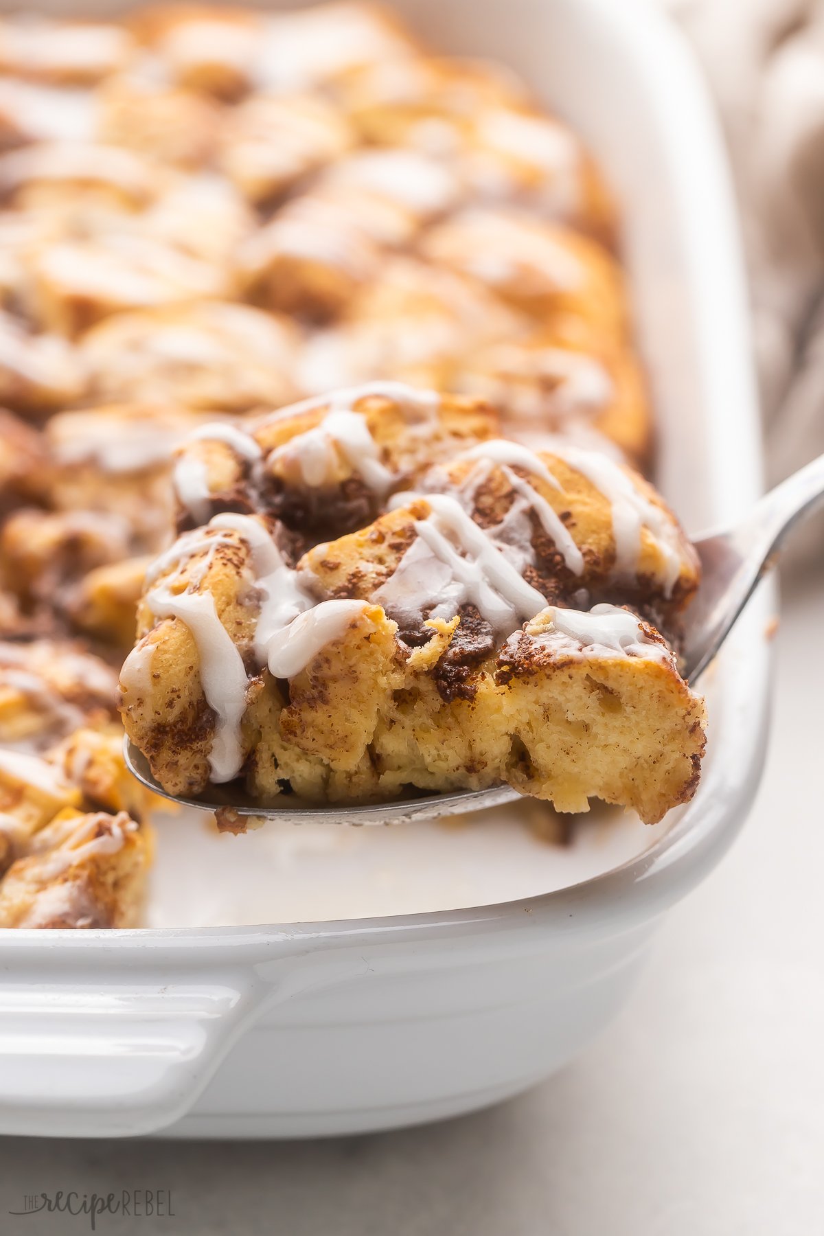 Close up of Cinnamon Roll Casserole with a fork taking out a slice.