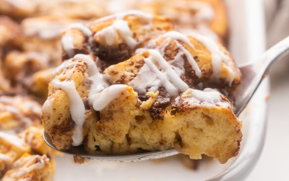 Close up of Cinnamon Roll Casserole with a fork taking out a slice.