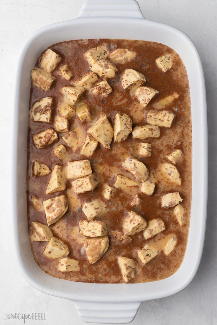 Top view of casserole dish with cinnamon roll mixture soaking.