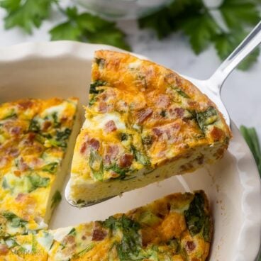 Close up view of a slice of Crustless Quiche being lifted from the dish.