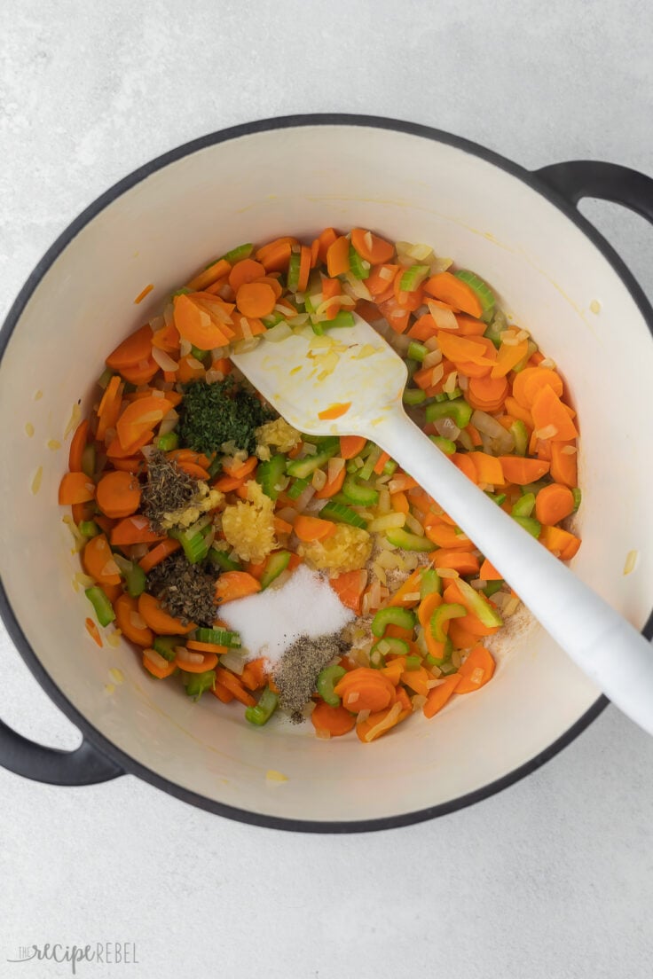 suateed vegetables in pot with spices and spatula.