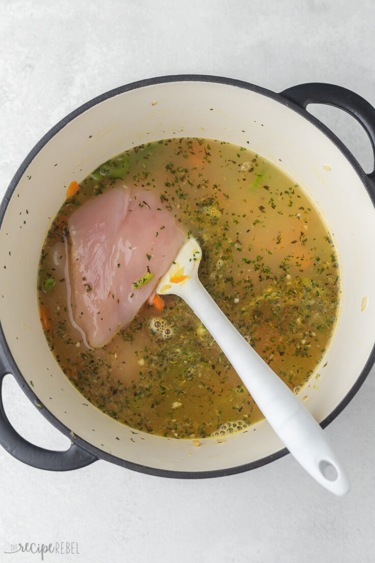 chicken breasts added into pot of soup.