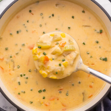 close up shot of metal ladle scooping soup out of pot.