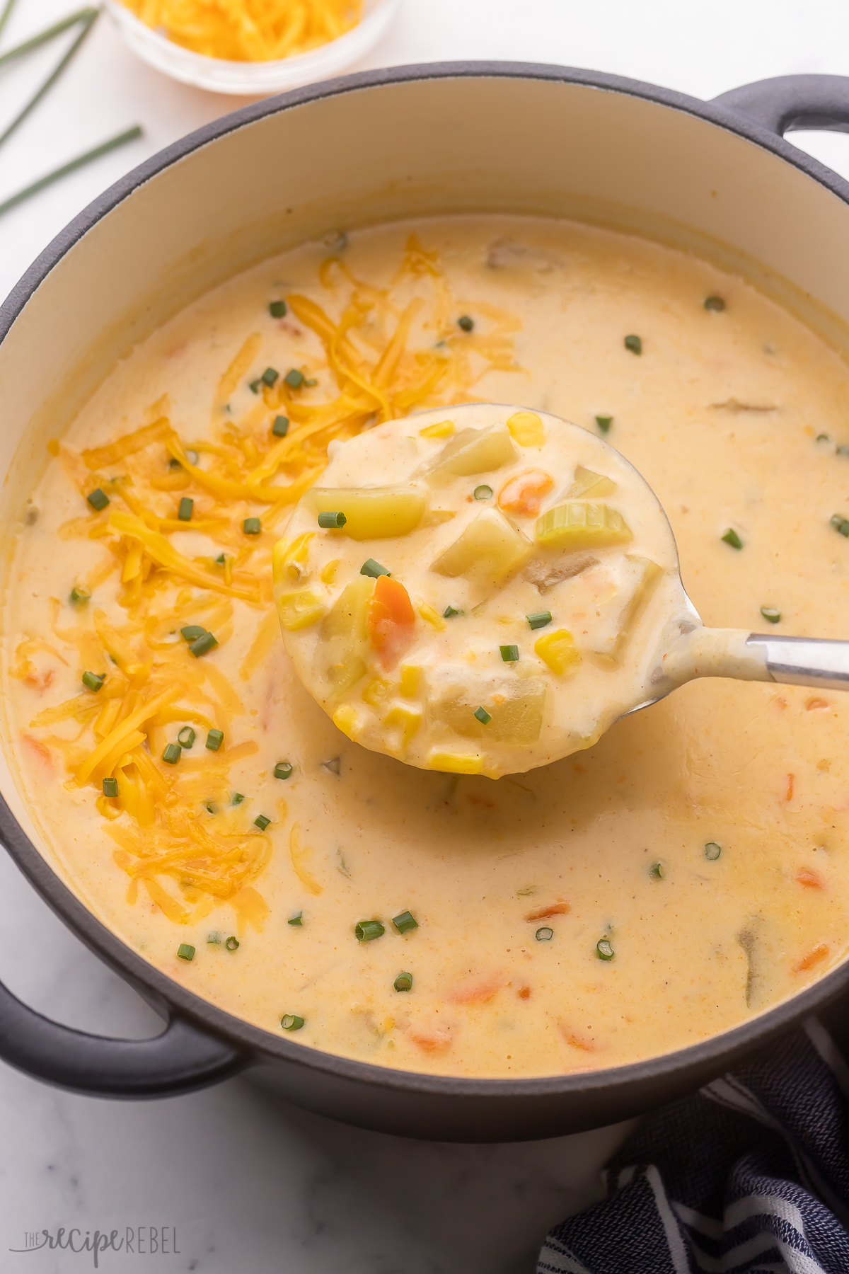 Creamy Nacho Potato Soup is packed with flavor - it's the perfect hearty comfort food! Made with Yukon gold potatoes, classic savory veggies, and yummy chicken broth, it's seasoned with cumin and chili powder for a classic Mexican flavor, with sweet corn and cheddar cheese! #soup #dinner | dinner ideas | soup recipes | healthy soup | potatoes | potato recipes | dinner ideas | comfort food steel ladle scooping nacho potato soup out of black pot.