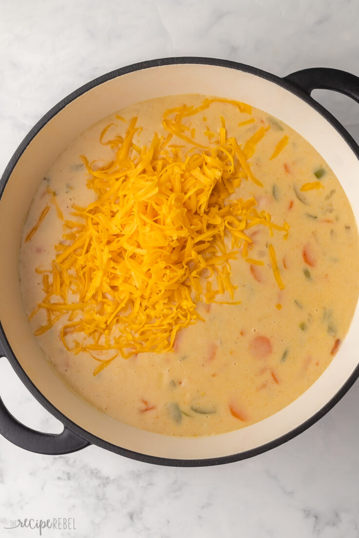 full pot of nacho potato soup with shredded cheese added to top.