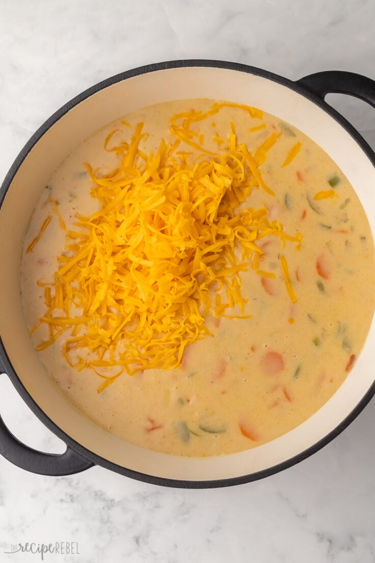 full pot of nacho potato soup with shredded cheese added to top.