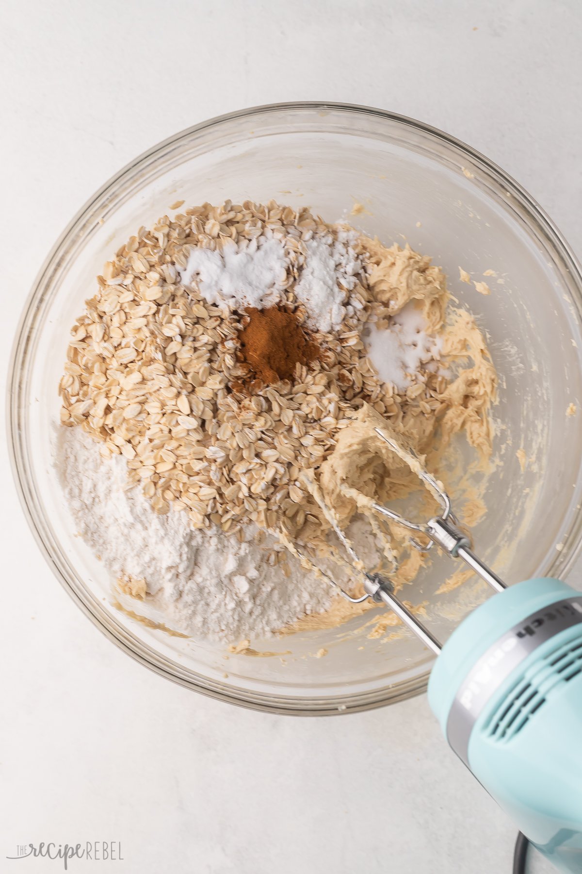 Top view of a glass mixing bowl with dry ingredients being mixed into a creamed mixture