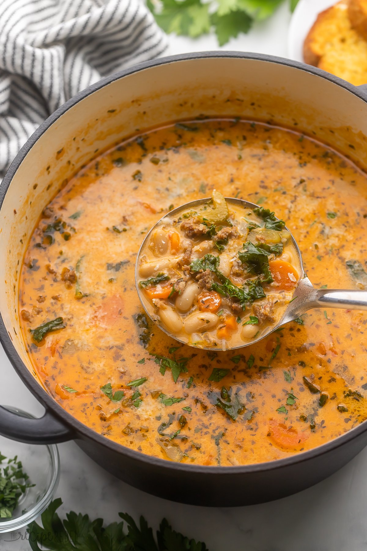 close up image of bean soup being ladled from pot.