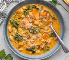 square image of tuscan bean soup in a blue bowl.