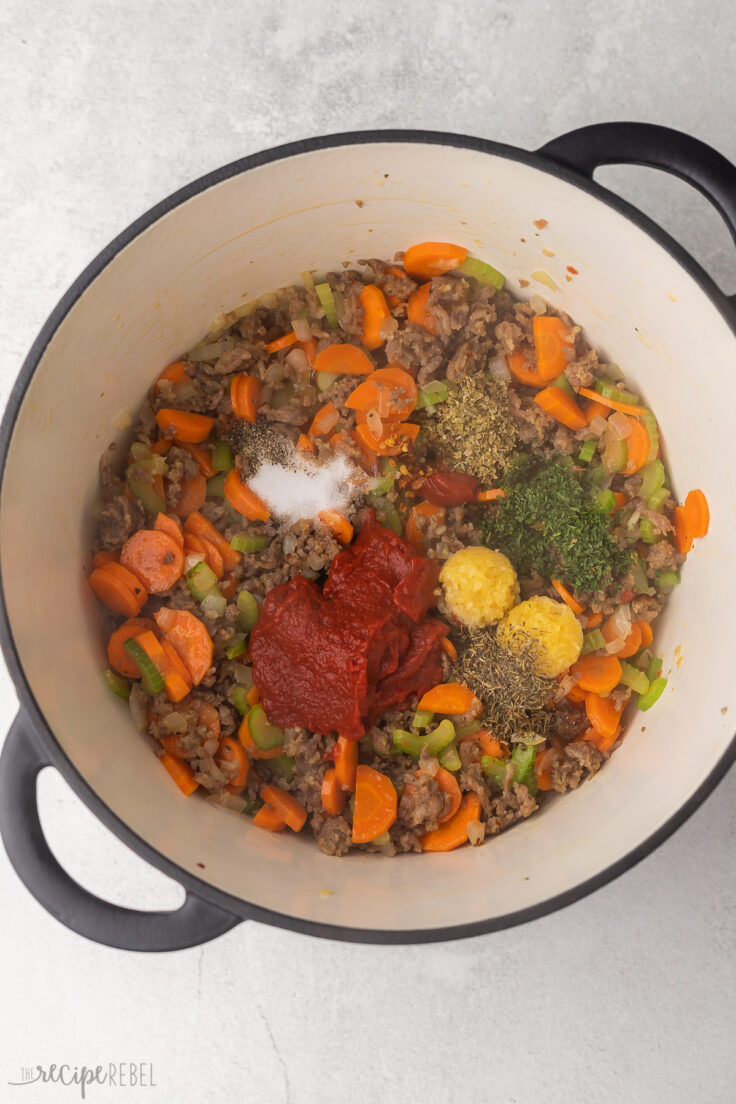 tomato paste and herbs and spices added to soup pot.